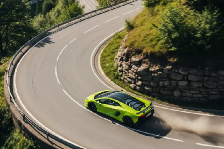 Bright green sports car navigating a sharp mountain curve on a paved road, surrounded by trees and rock embankments