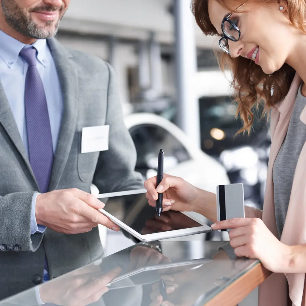 business client signing vehicle registration documents with dealership representative for Montana registration processing