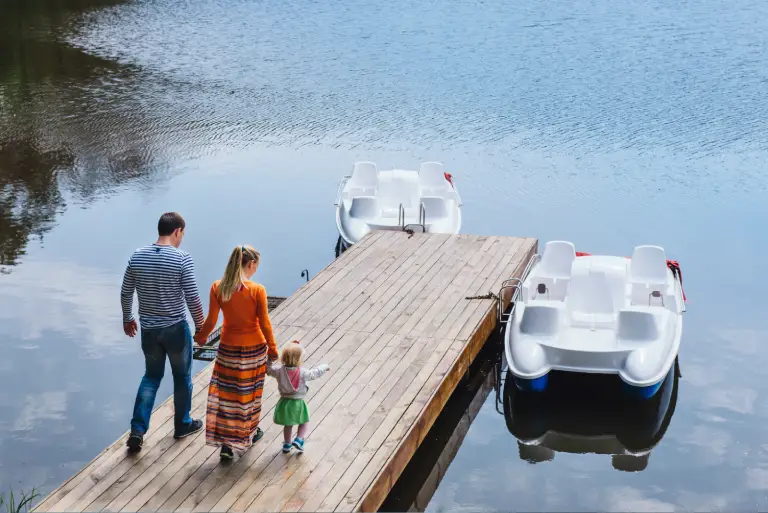 family walking on dock toward boat representing Montana vehicle registration for recreational watercraft